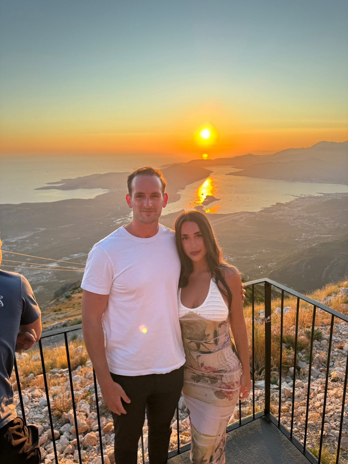 A couple at sunset on a mountain overlook above the coastline near Kotor, Montenegro